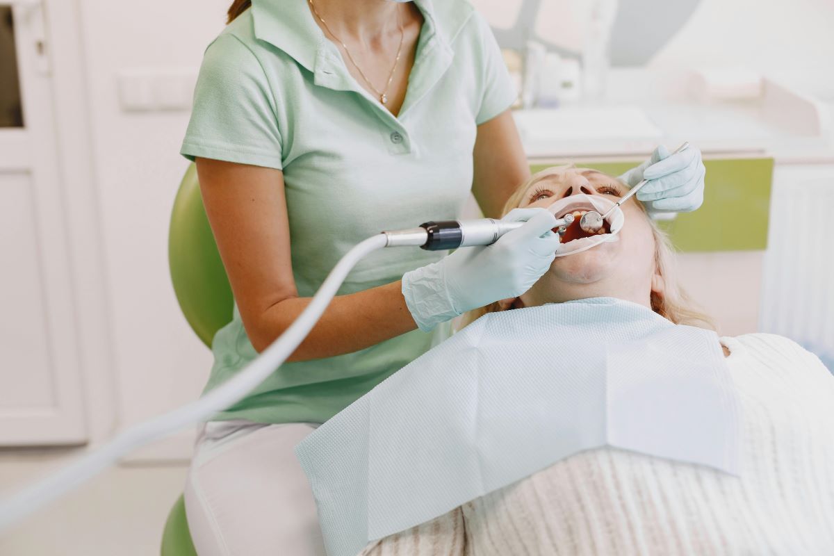 Dental hygienist performing professional teeth cleaning and scaling during a dental hygiene appointment in Milton